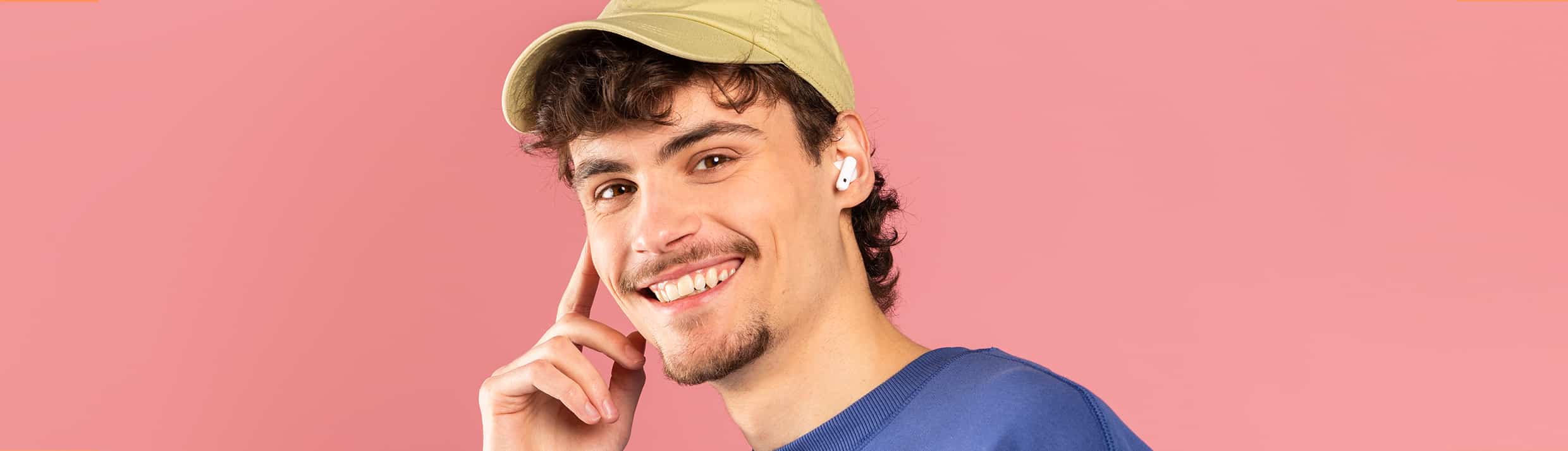 Un homme porte des Apple AirPods sans fil et sourit gentiment à la caméra.