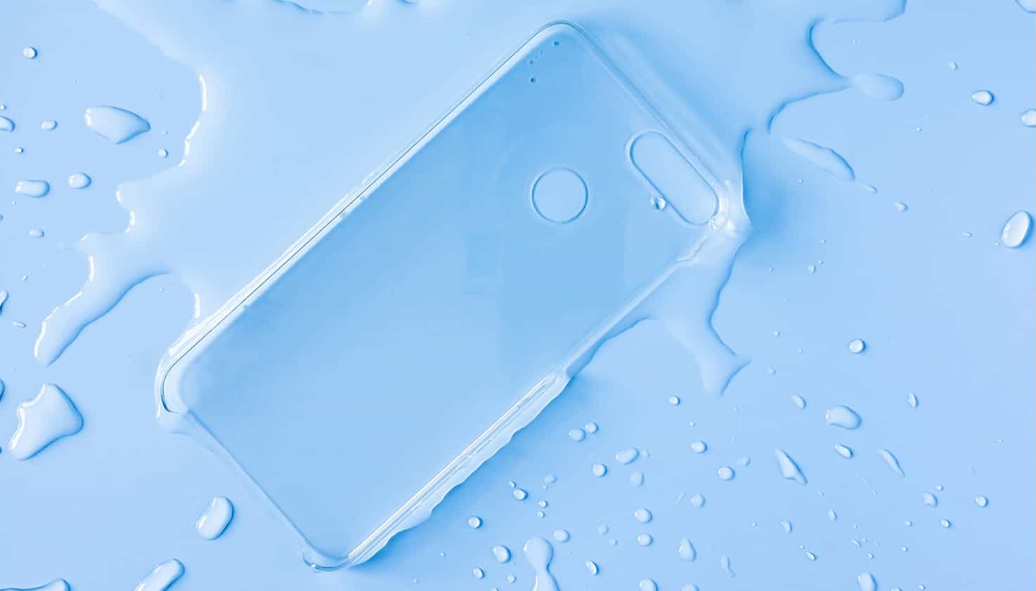 Une coque de téléphone transparente est posée dans une flaque d'eau avec des éclaboussures autour.