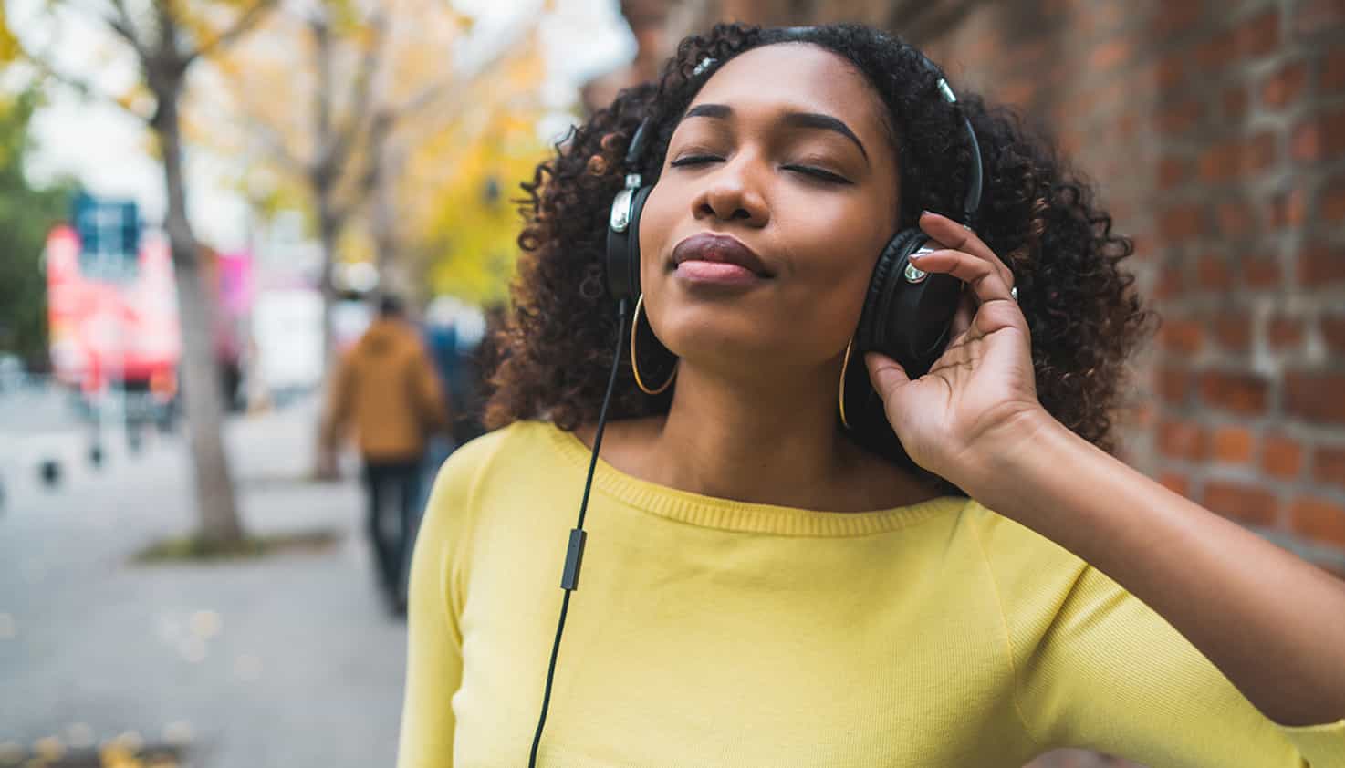 Le modèle féminin porte un casque sans fil autour de son cou et le modèle masculin porte un casque filaire.