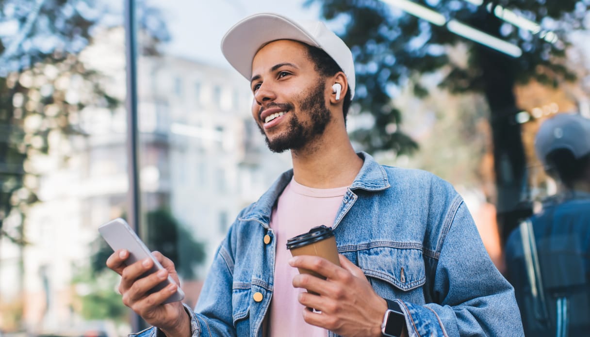 Vous voyez un homme avec ses AirPods et son iPhone dans la main.