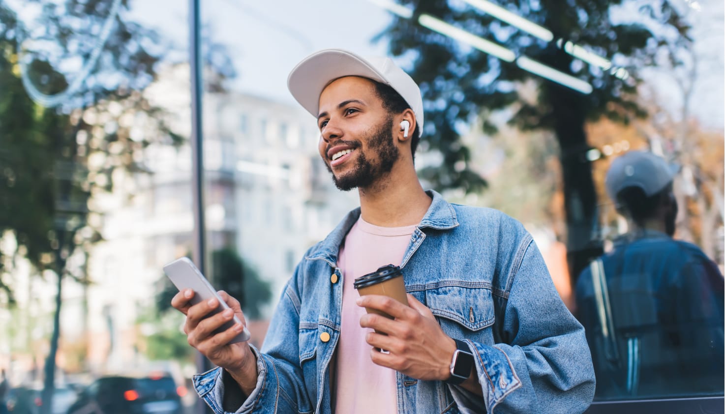 Vous voyez un homme avec ses AirPods et son iPhone dans la main.